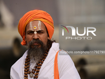 A Sadhu (holy man) walks on the banks of the Sangam area as he arrives for the allotment of land for the Maha Kumbh 2025 Festival in Prayagr...