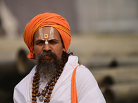 A Sadhu (holy man) walks on the banks of the Sangam area as he arrives for the allotment of land for the Maha Kumbh 2025 Festival in Prayagr...