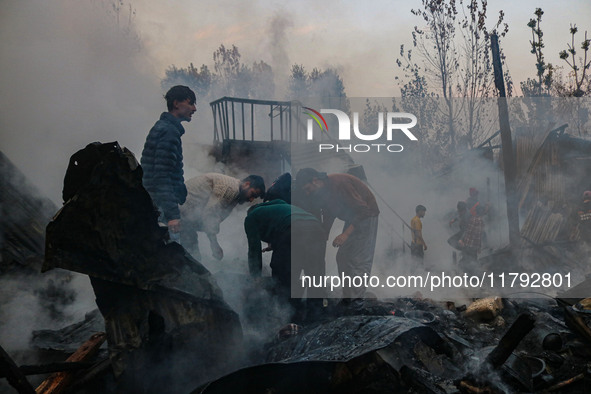 Civilians work to extinguish a fire on residential houses in Srinagar, Jammu and Kashmir, on November 19, 2024. 