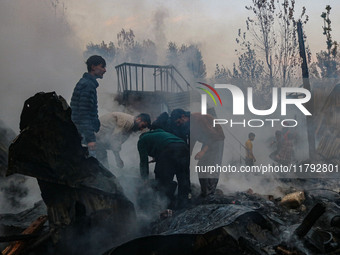 Civilians work to extinguish a fire on residential houses in Srinagar, Jammu and Kashmir, on November 19, 2024. (