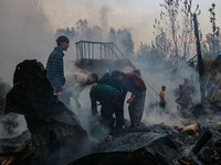 Civilians work to extinguish a fire on residential houses in Srinagar, Jammu and Kashmir, on November 19, 2024. (