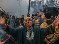 A woman reacts as firefighters and civilians work to extinguish a fire on residential houses in Srinagar, Jammu and Kashmir, on November 19,...