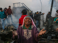 A woman reacts as firefighters and civilians work to extinguish a fire on residential houses in Srinagar, Jammu and Kashmir, on November 19,...