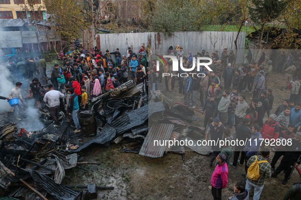 Firefighters and civilians work to extinguish a fire on residential houses in Srinagar, Jammu and Kashmir, on November 19, 2024. 