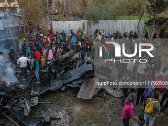 Firefighters and civilians work to extinguish a fire on residential houses in Srinagar, Jammu and Kashmir, on November 19, 2024. (