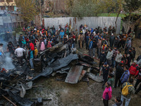 Firefighters and civilians work to extinguish a fire on residential houses in Srinagar, Jammu and Kashmir, on November 19, 2024. (