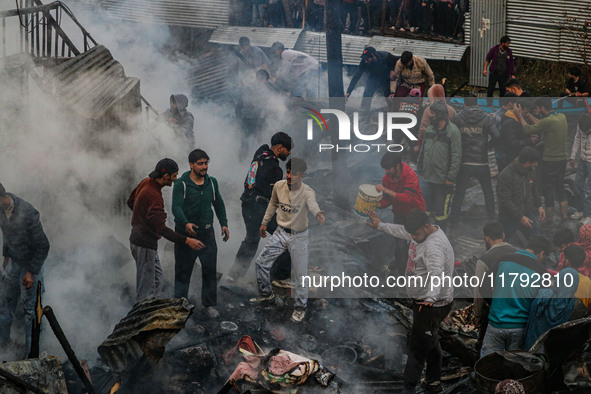 Firefighters and civilians work to extinguish a fire on residential houses in Srinagar, Jammu and Kashmir, on November 19, 2024. 