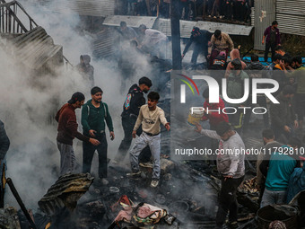 Firefighters and civilians work to extinguish a fire on residential houses in Srinagar, Jammu and Kashmir, on November 19, 2024. (