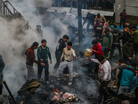 Firefighters and civilians work to extinguish a fire on residential houses in Srinagar, Jammu and Kashmir, on November 19, 2024. (