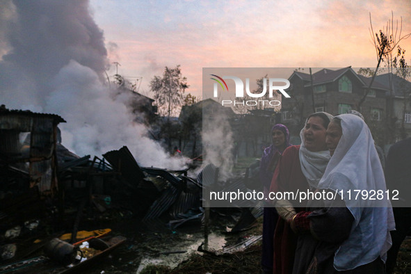 Women weep as firefighters and civilians work to extinguish a fire on residential houses in Srinagar, Jammu and Kashmir, on November 19, 202...