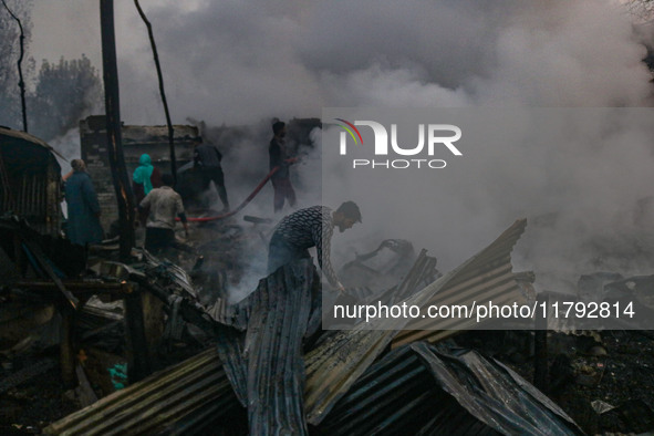 Civilians work to extinguish a fire on residential houses in Srinagar, Jammu and Kashmir, on November 19, 2024. 