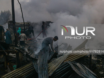 Civilians work to extinguish a fire on residential houses in Srinagar, Jammu and Kashmir, on November 19, 2024. (