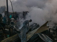 Civilians work to extinguish a fire on residential houses in Srinagar, Jammu and Kashmir, on November 19, 2024. (