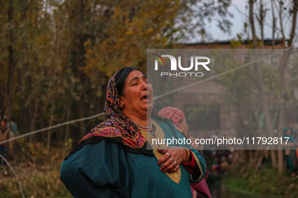 A woman weeps as firefighters and civilians work to extinguish a fire on residential houses in Srinagar, Jammu and Kashmir, on November 19,...