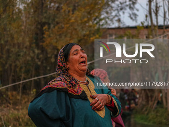 A woman weeps as firefighters and civilians work to extinguish a fire on residential houses in Srinagar, Jammu and Kashmir, on November 19,...