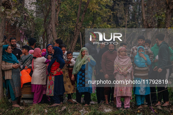 People watch from a distance as firefighters work to extinguish a fire on residential houses in Srinagar, Jammu and Kashmir, on November 19,...