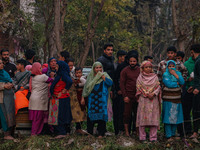 People watch from a distance as firefighters work to extinguish a fire on residential houses in Srinagar, Jammu and Kashmir, on November 19,...