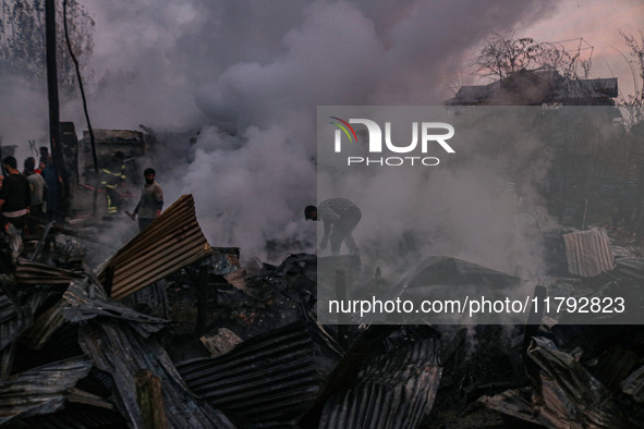 Civilians work to extinguish a fire on residential houses in Srinagar, Jammu and Kashmir, on November 19, 2024. 