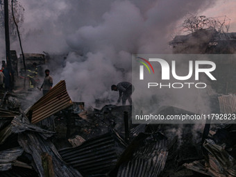 Civilians work to extinguish a fire on residential houses in Srinagar, Jammu and Kashmir, on November 19, 2024. (