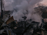 Civilians work to extinguish a fire on residential houses in Srinagar, Jammu and Kashmir, on November 19, 2024. (