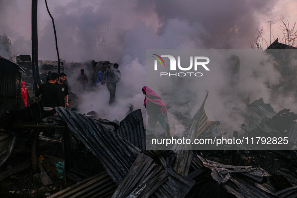 Civilians work to extinguish a fire on residential houses in Srinagar, Jammu and Kashmir, on November 19, 2024. 