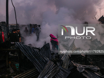 Civilians work to extinguish a fire on residential houses in Srinagar, Jammu and Kashmir, on November 19, 2024. (