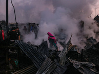 Civilians work to extinguish a fire on residential houses in Srinagar, Jammu and Kashmir, on November 19, 2024. (