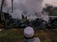 An elderly man watches as civilians work to extinguish a fire on residential houses in Srinagar, Jammu and Kashmir, on November 19, 2024. (