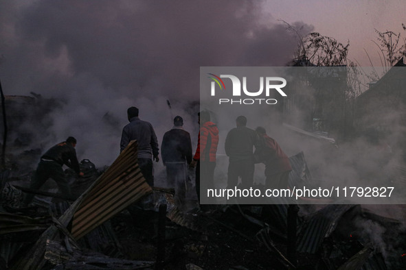 Firefighters and civilians work to extinguish a fire on residential houses in Srinagar, Jammu and Kashmir, on November 19, 2024. 