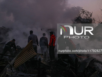 Firefighters and civilians work to extinguish a fire on residential houses in Srinagar, Jammu and Kashmir, on November 19, 2024. (