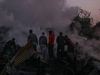 Firefighters and civilians work to extinguish a fire on residential houses in Srinagar, Jammu and Kashmir, on November 19, 2024. (