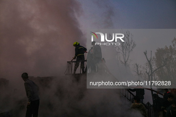 Firefighters and civilians work to extinguish a fire on residential houses in Srinagar, Jammu and Kashmir, on November 19, 2024. 