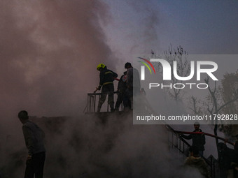 Firefighters and civilians work to extinguish a fire on residential houses in Srinagar, Jammu and Kashmir, on November 19, 2024. (