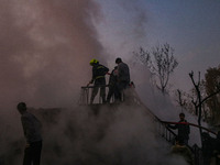 Firefighters and civilians work to extinguish a fire on residential houses in Srinagar, Jammu and Kashmir, on November 19, 2024. (