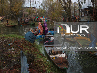 People transport their belongings in boats as firefighters and civilians work to extinguish a fire on residential houses in Srinagar, Jammu...