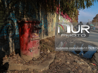 Girls walk past an old India Post letterbox in Sopore, Jammu and Kashmir, India, on November 19, 2024. (