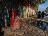 Girls walk past an old India Post letterbox in Sopore, Jammu and Kashmir, India, on November 19, 2024. (