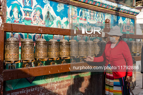 A devotee rounds the prayer wheel around the Boudhanath Stupa in Kathmandu, Nepal, on November 19, 2024. 