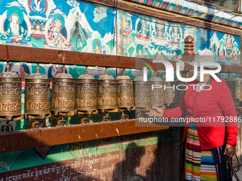 A devotee rounds the prayer wheel around the Boudhanath Stupa in Kathmandu, Nepal, on November 19, 2024. (