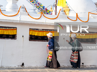 A devotee rounds the prayer wheel around the Boudhanath Stupa in Kathmandu, Nepal, on November 19, 2024. (