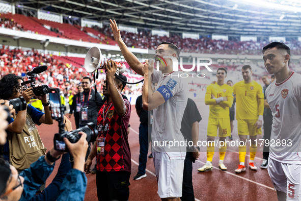 Jay Noah Idzes of Indonesia talks to a supporter after celebrating their victory in the FIFA World Cup Asian 3rd Qualifier Group C match aga...