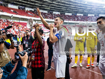 Jay Noah Idzes of Indonesia talks to a supporter after celebrating their victory in the FIFA World Cup Asian 3rd Qualifier Group C match aga...