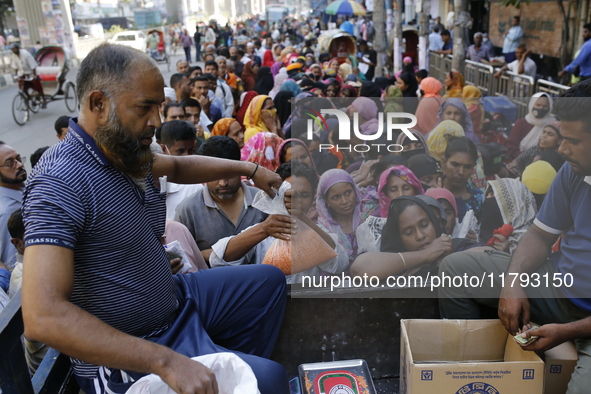 Lower-income people stand in line to buy government-subsidized food in Dhaka, Bangladesh, on November 19, 2024. 