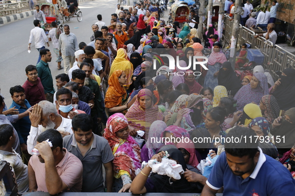 Lower-income people stand in line to buy government-subsidized food in Dhaka, Bangladesh, on November 19, 2024. 