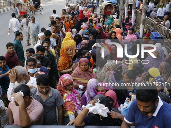 Lower-income people stand in line to buy government-subsidized food in Dhaka, Bangladesh, on November 19, 2024. (