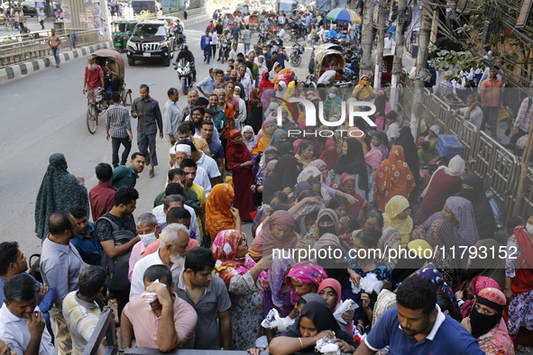 Lower-income people stand in line to buy government-subsidized food in Dhaka, Bangladesh, on November 19, 2024. 