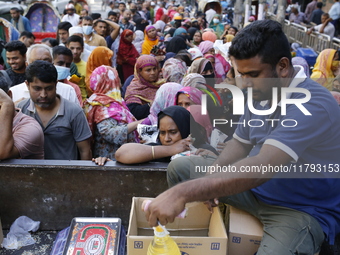 Lower-income people stand in line to buy government-subsidized food in Dhaka, Bangladesh, on November 19, 2024. (