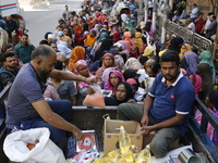 Lower-income people stand in line to buy government-subsidized food in Dhaka, Bangladesh, on November 19, 2024. (