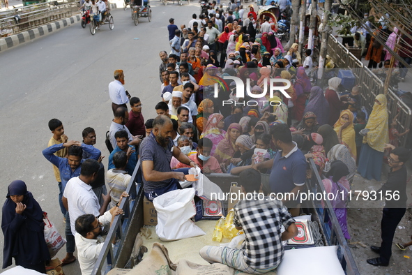 Lower-income people stand in line to buy government-subsidized food in Dhaka, Bangladesh, on November 19, 2024. 