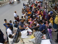 Lower-income people stand in line to buy government-subsidized food in Dhaka, Bangladesh, on November 19, 2024. (